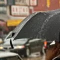 People carrying umbrellas on a rainy street in Toronto's Chinatown