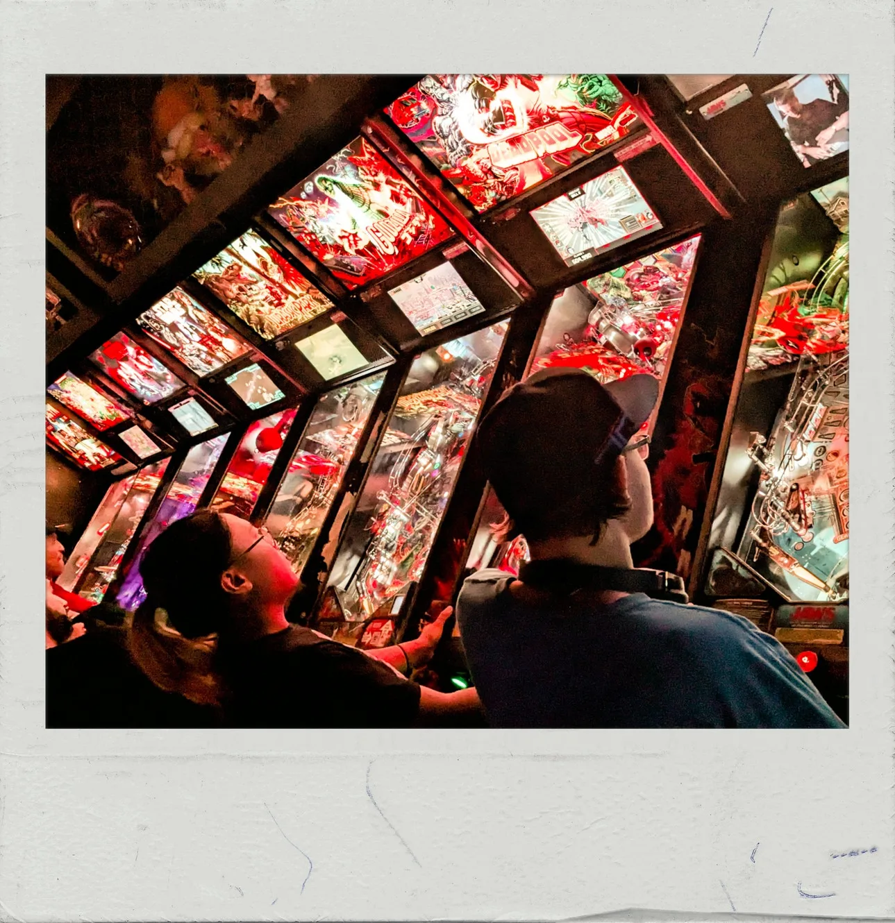 People playing a pinball machine at FreePlay Toronto