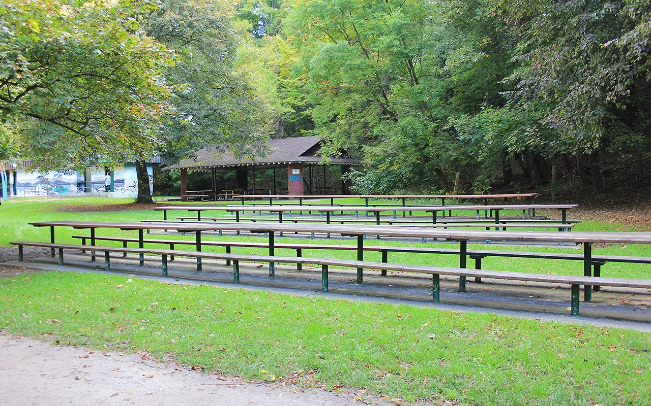 Picnic tables and a small shelter among trees at Sherwood Park
