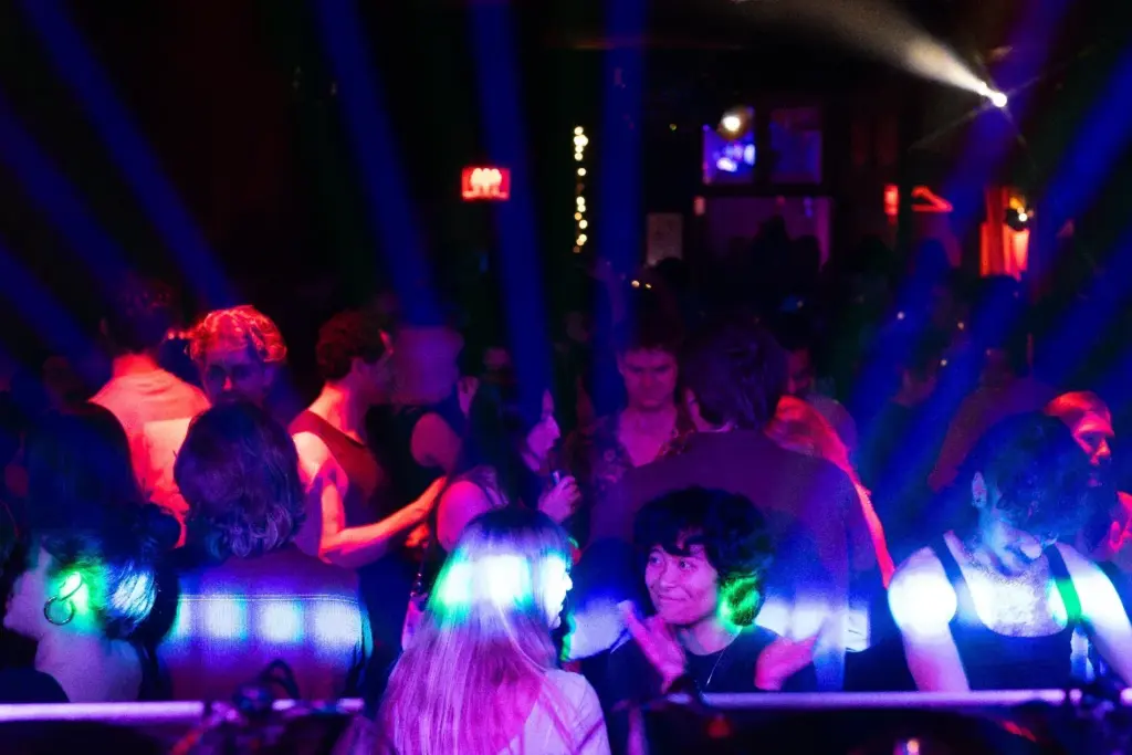 DJs and dancers at a colourful party inside The Piston