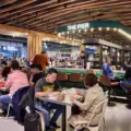 People eating at common tables inside Wellington Market at The Well