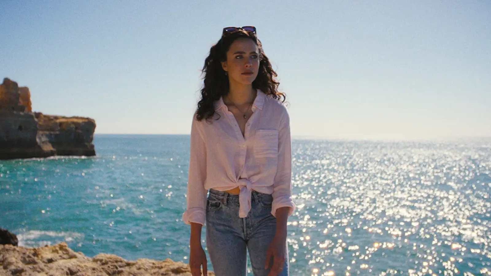 Margaret Qualley sits beside a child in a scene from Love of Your Life