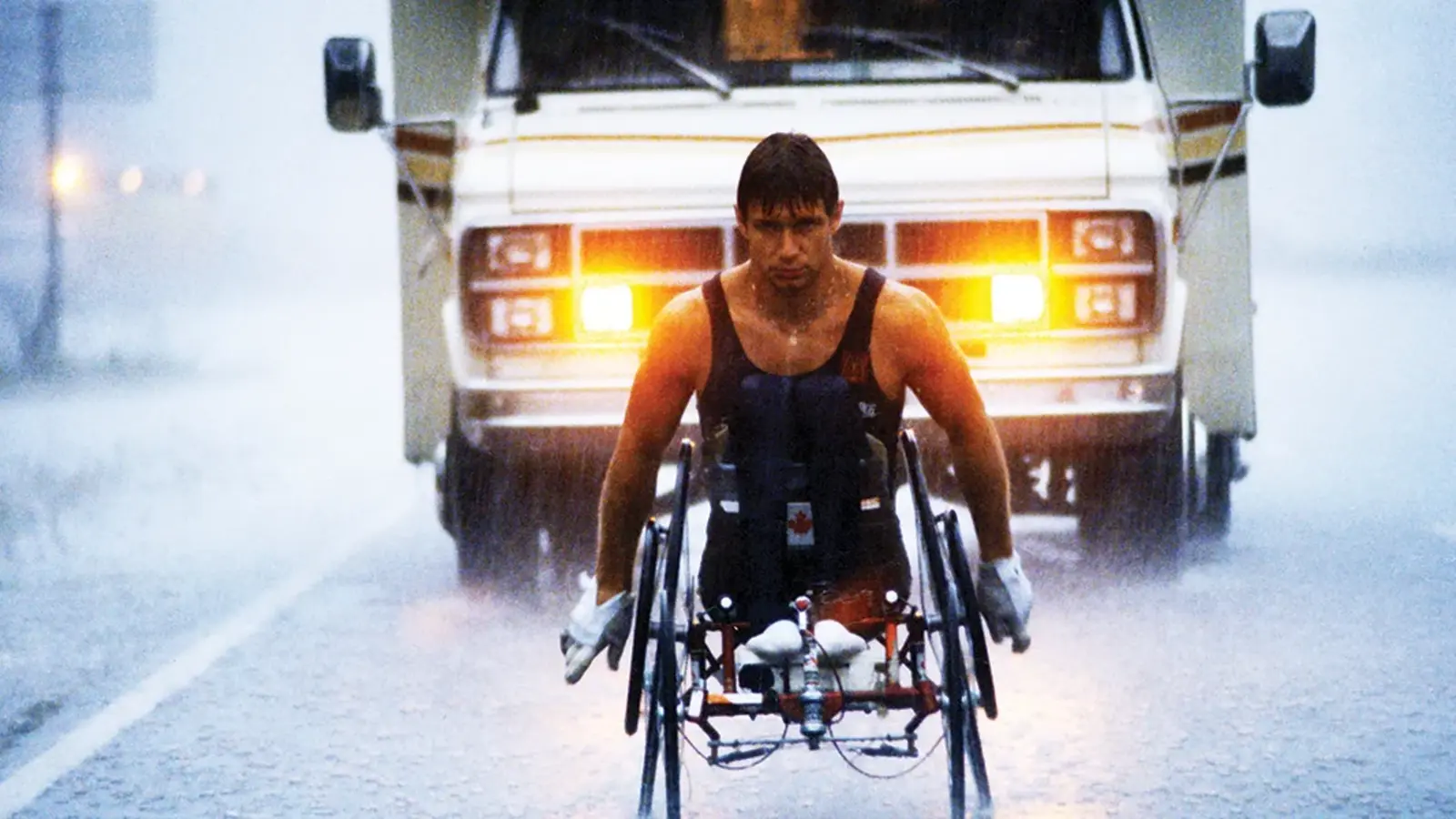 Rick Hansen travels along a rainy road in Man in Motion