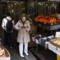 A shopper choosing fruit and vegetables at a Toronto Chinatown market