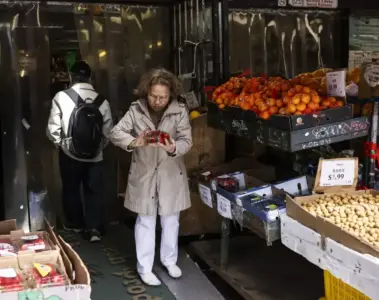 A shopper choosing fruit and vegetables at a Toronto Chinatown market