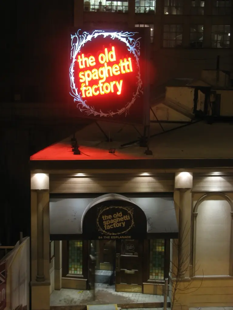 Old Spaghetti Factory entrance and neon sign at night on The Esplanade in Toronto