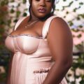 A plus-size woman wearing an elegant formal dress outdoors