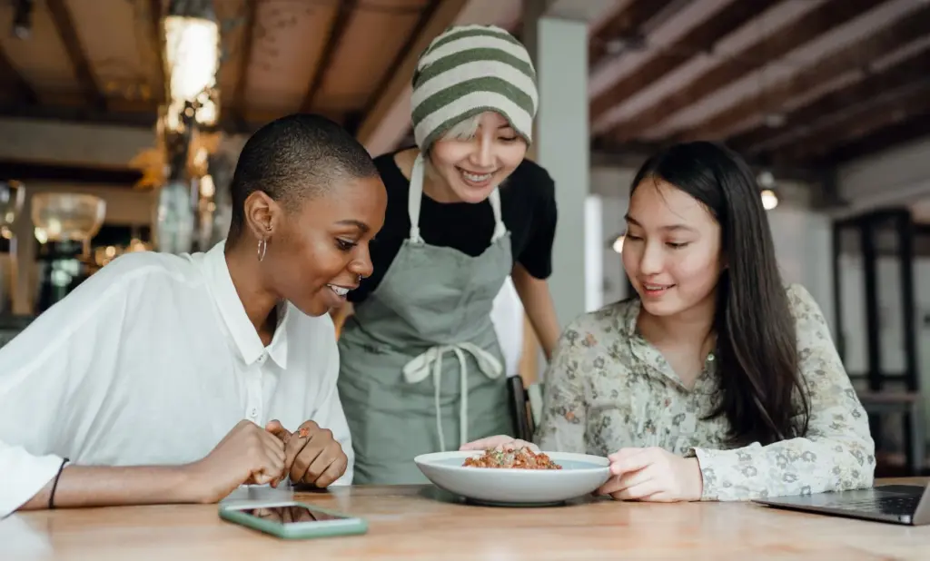 Three women sharing a casual restaurant meal at a table