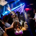 A diverse group celebrates with bottle service inside SU Karaoke