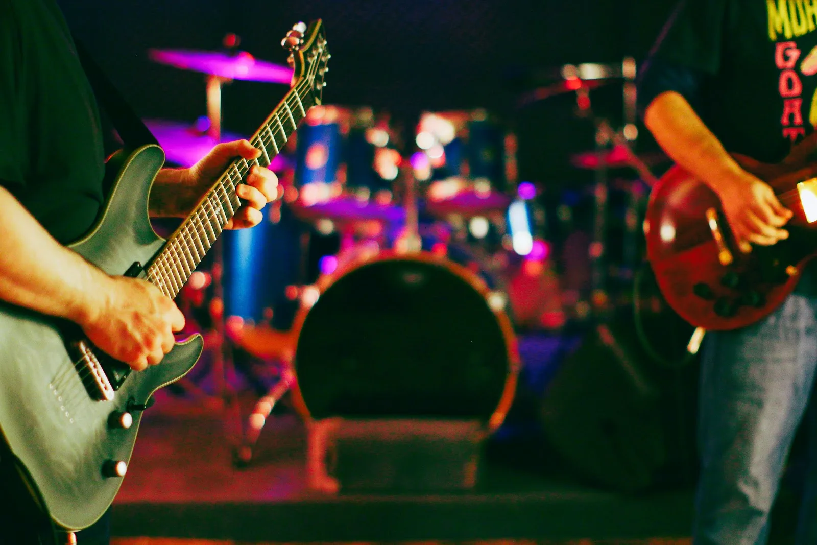 Two musicians play guitars inside a rehearsal studio at The Best Deal in Town