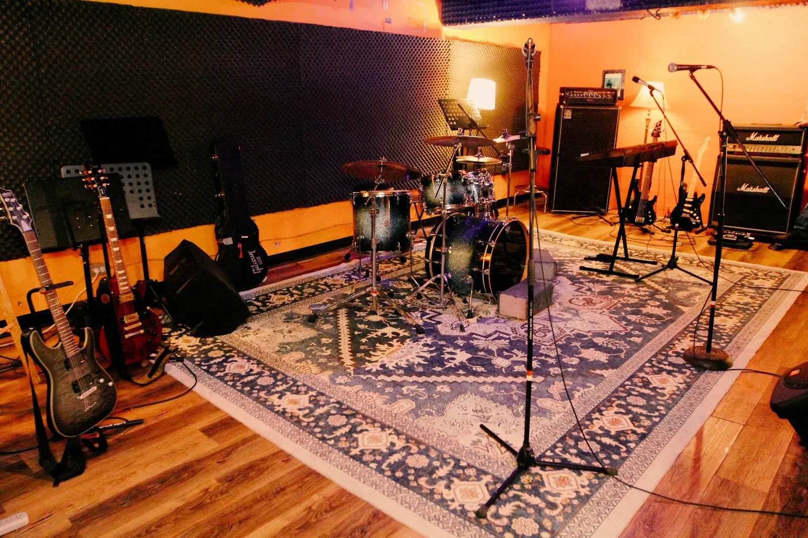 An equipped rehearsal room with drums, microphones and amplifiers