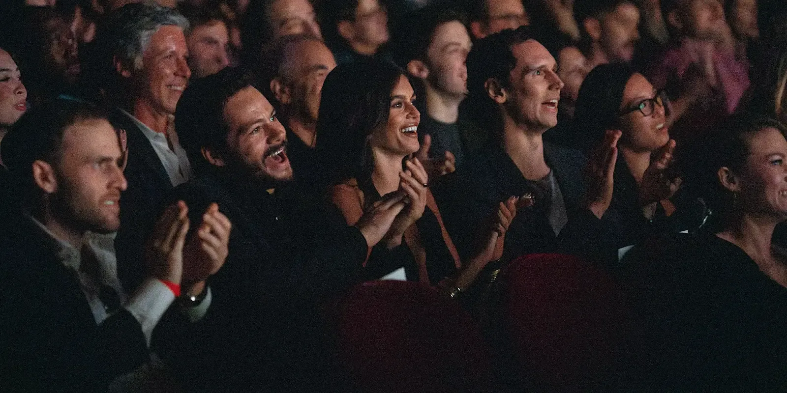 A diverse audience smiles and applauds inside a TIFF cinema