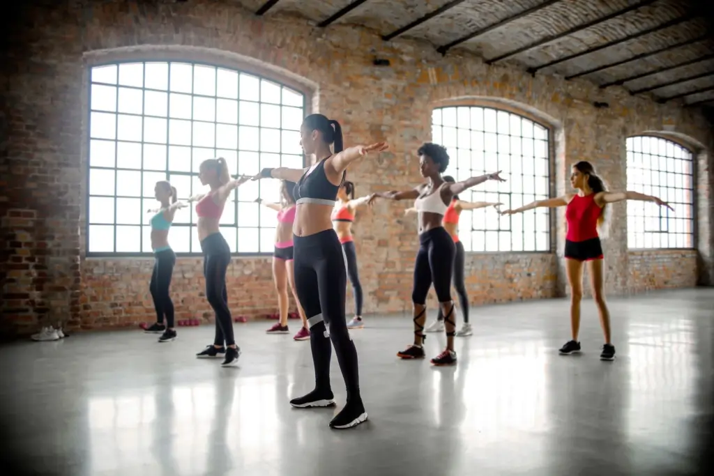 Diverse group of women following an instructor in a bright fitness studio
