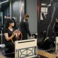 Women and instructors using reformer machines in a Pilates studio