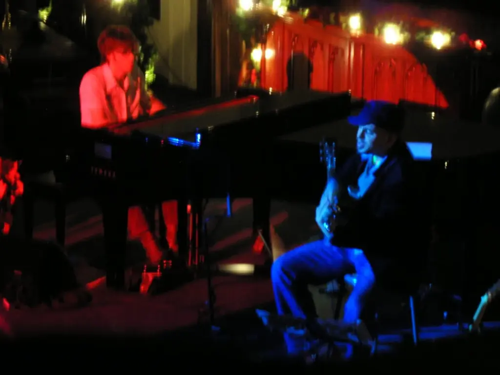 Musicians performing under red and blue lights in a small Toronto venue