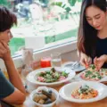 Three women sharing pizza and drinks at a casual table