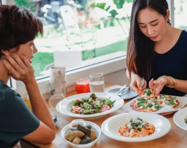 Three women sharing pizza and drinks at a casual table