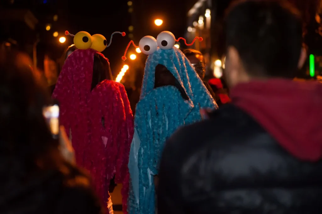 Two visitors wearing colourful furry monster costumes