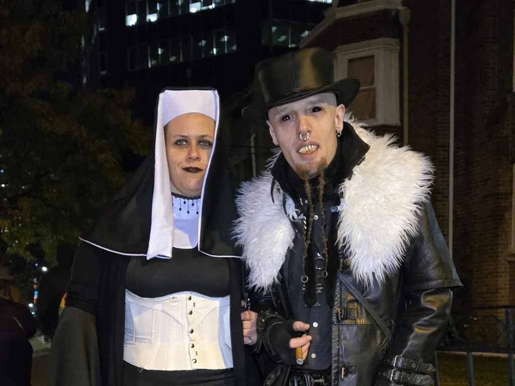 Two Halloween visitors in a nun costume and a top hat on Church Street