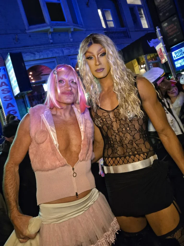 Two costumed visitors posing together during Halloween in the Village