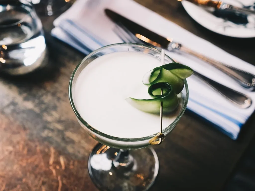 A cocktail with a cucumber garnish at Cluny
