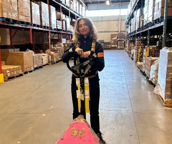 A volunteer with a pallet jack in the Daily Bread Food Bank warehouse