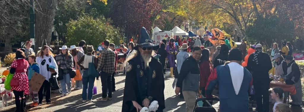 Costumed families walking together along a residential street