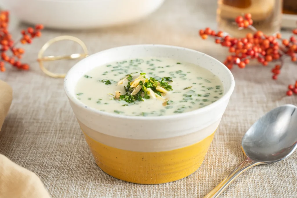 A bowl of creamy soup with herbs on a Thanksgiving table