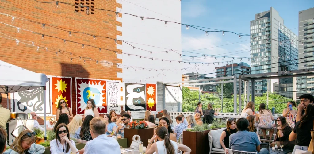 People seated on the open-air Sky Yard patio at The Drake Hotel