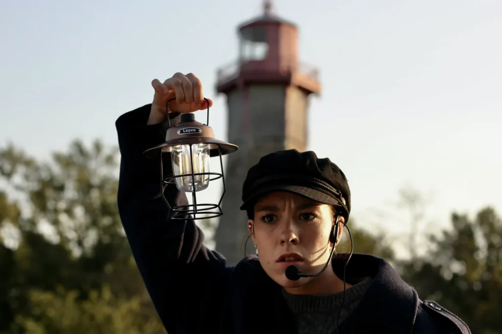 A costumed Haunted Harbour storyteller holding a lantern near Gibraltar Point Lighthouse