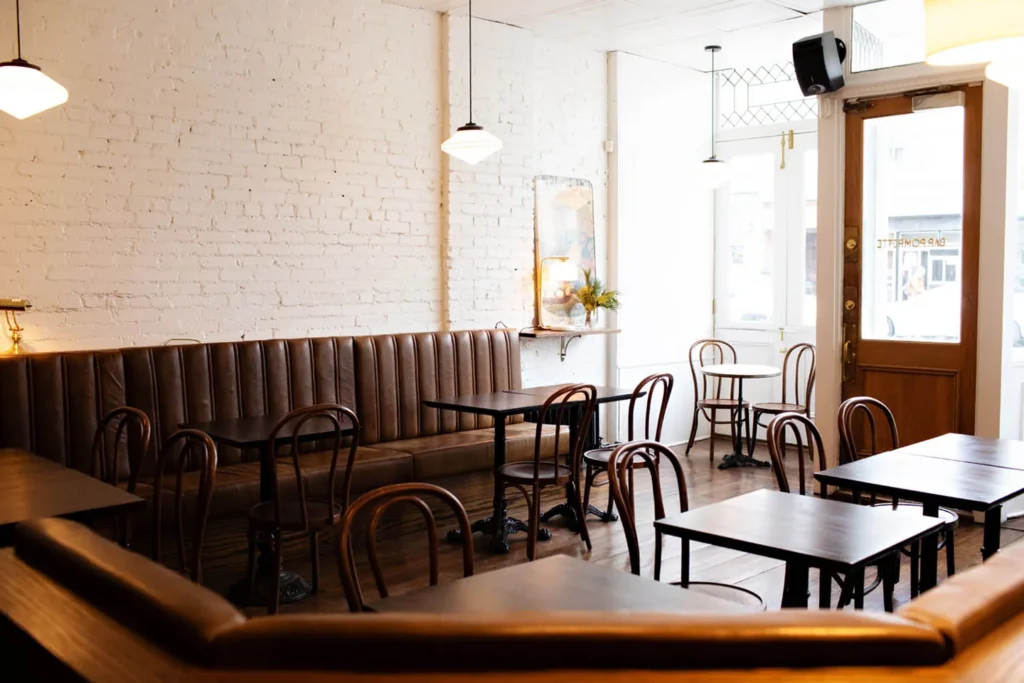 Benches and small tables in the front room at Bar Pompette