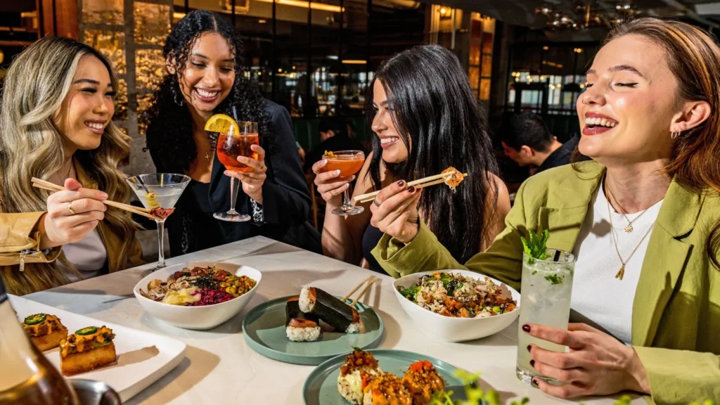 Four women sharing food and drinks at Chefs Hall