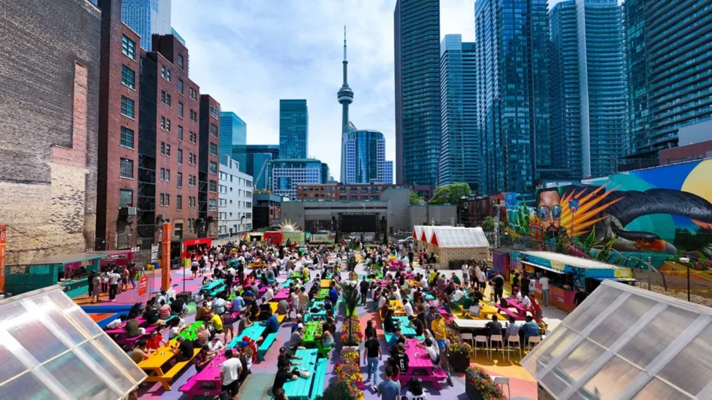 A daytime crowd facing the outdoor screen at RendezViews