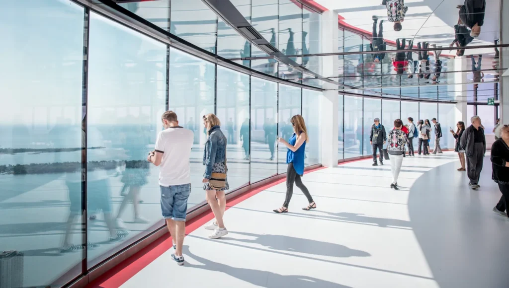 Visitors beside tall windows on a CN Tower observation level