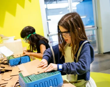 Two girls building cardboard projects at Innovation Station