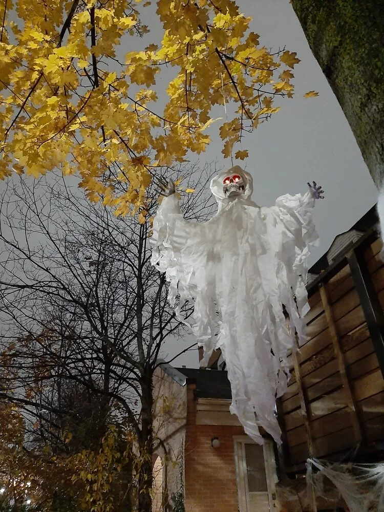 A hanging ghost decoration above a Toronto front garden