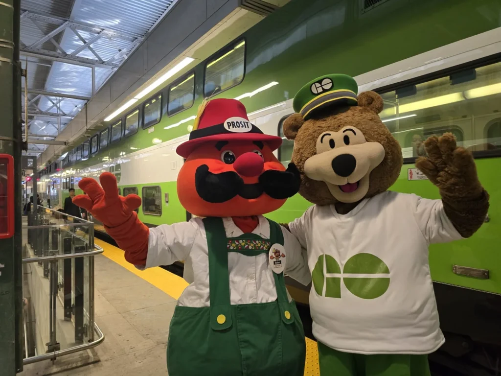 Oktoberfest mascots beside a GO train