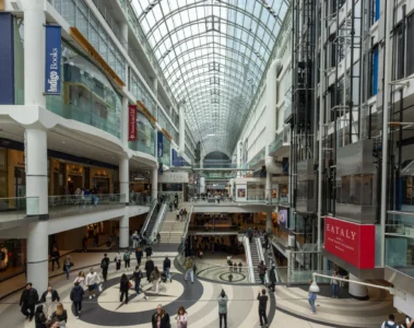 Shoppers on several levels beneath the glass roof at Toronto Eaton Centre