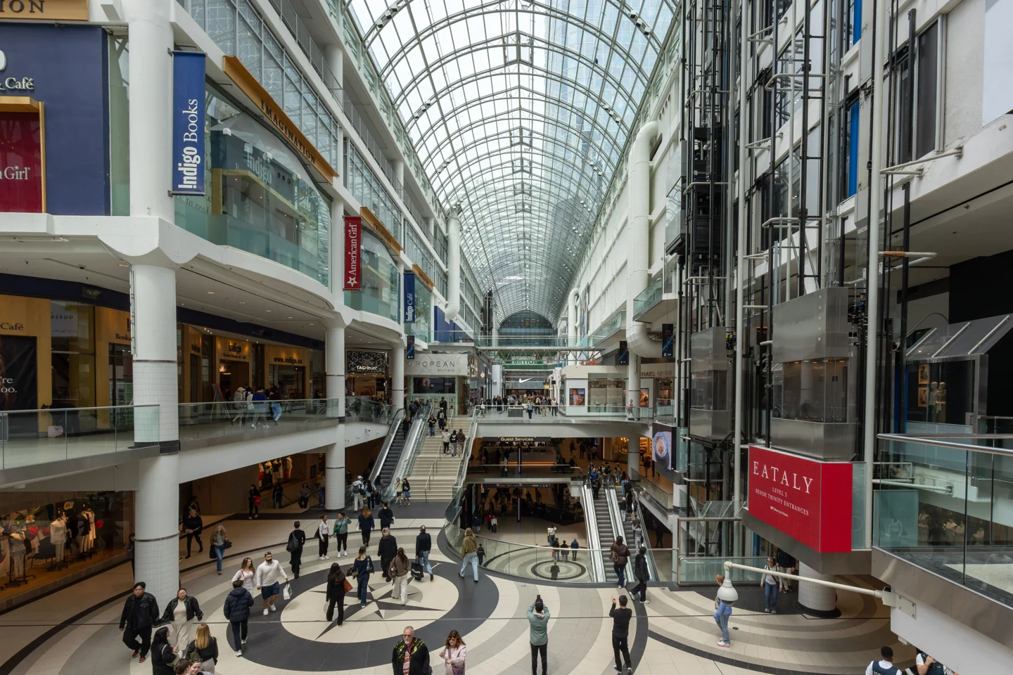 Shoppers on several levels beneath the glass roof at Toronto Eaton Centre