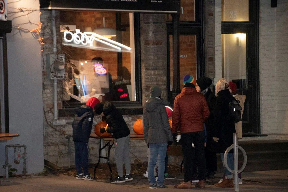 Families admiring pumpkins at Harbord Village PumpkinFest