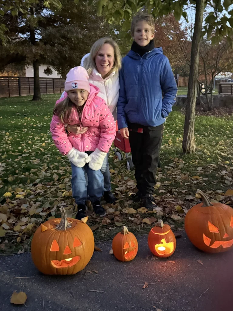 An adult and children beside carved pumpkins at Silver Creek Park