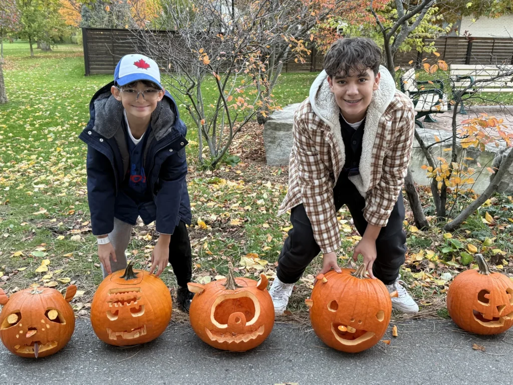 Children arranging pumpkins along a park path at Silver Creek