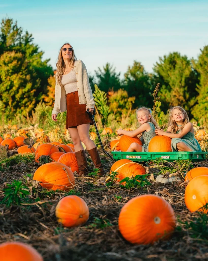 A woman and children with a wagon among pumpkins at Brantwood Farms