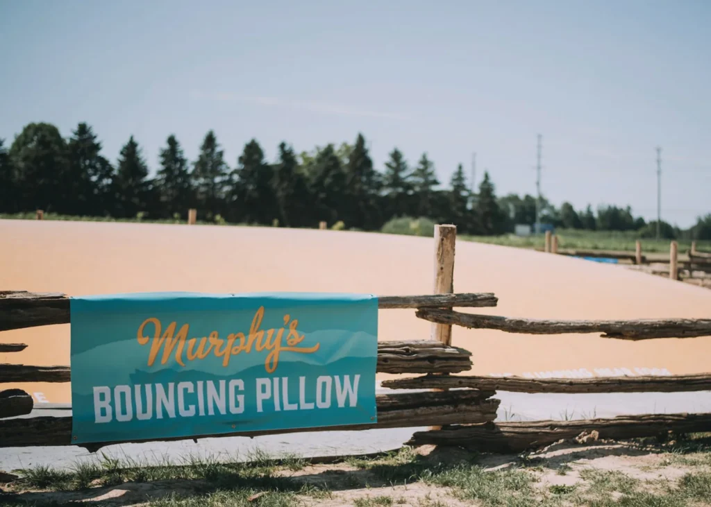 Bouncing pillow behind a wooden fence at Murphy’s Farm