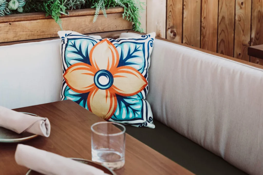 A table with flowers and cushions on the Baro rooftop