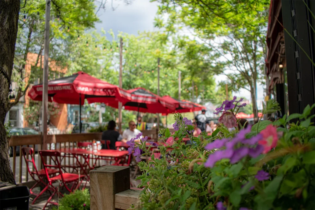 Tables and red umbrellas on the KOS patio in Kensington Market