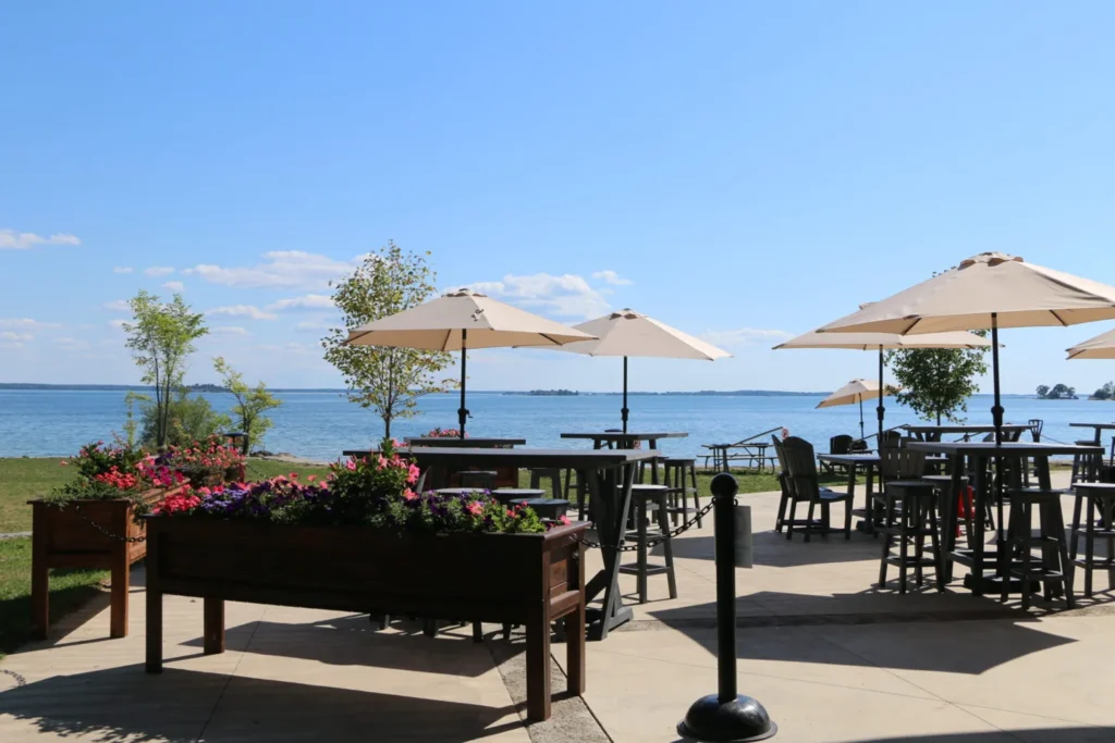 Patio tables and umbrellas overlooking the water at Browns Bay