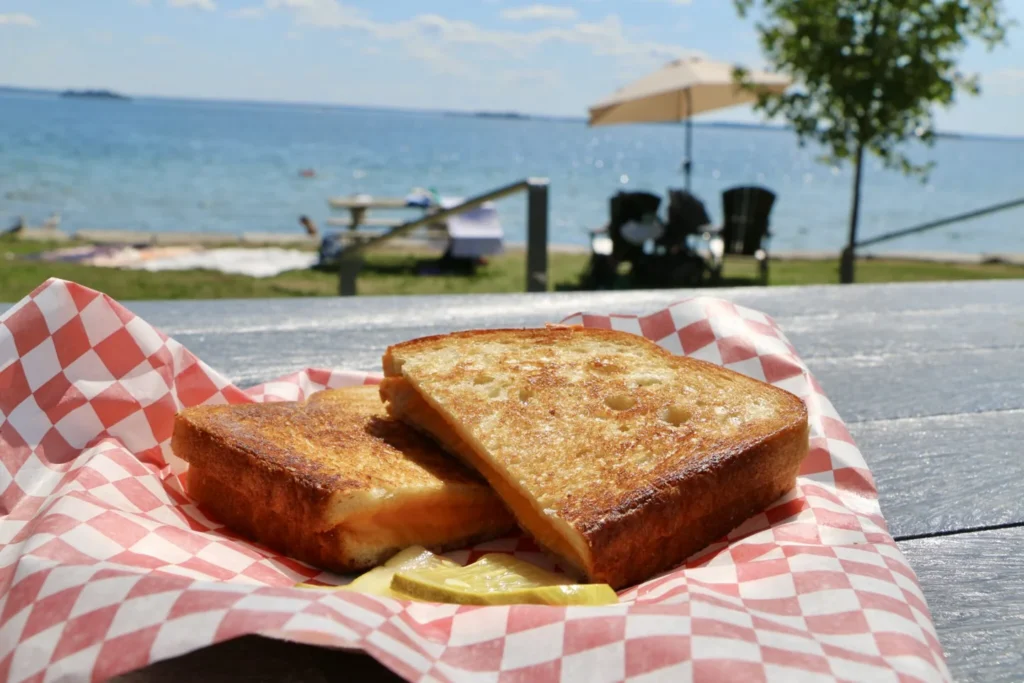 Grilled cheese sandwich in a basket beside the water at Browns Bay