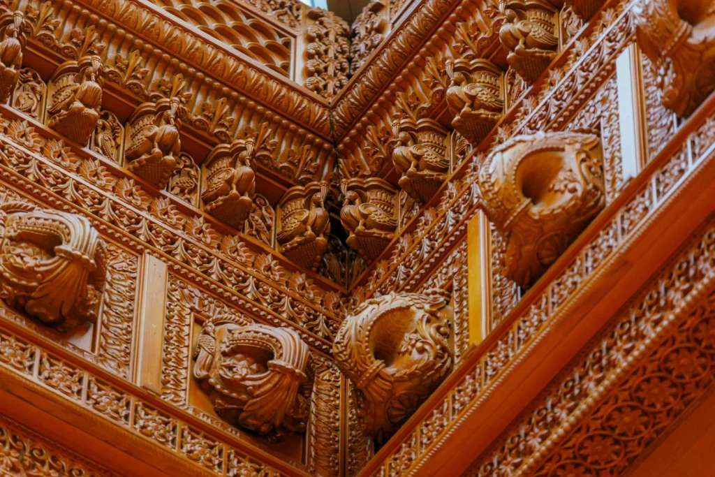 Detailed wooden carvings on a corner inside the Toronto Haveli