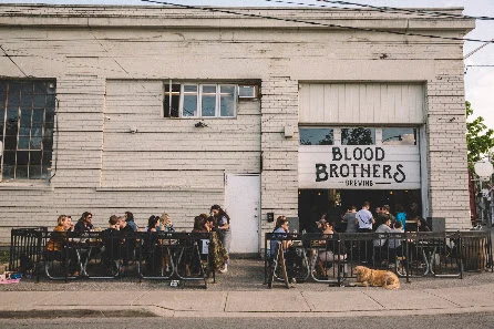 People seated outside Blood Brothers Brewing on Geary Avenue in April 2023